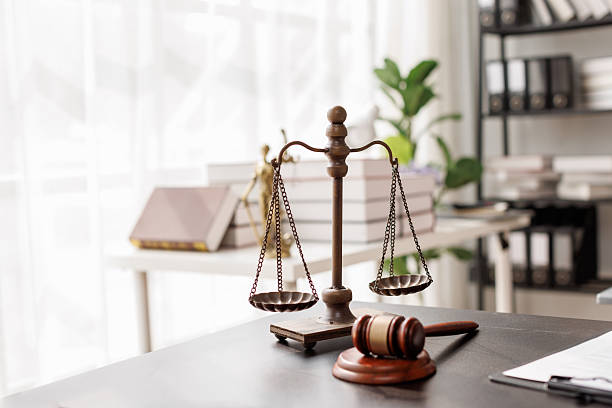 Balance scales and a wooden gavel on a desk in a bright office
